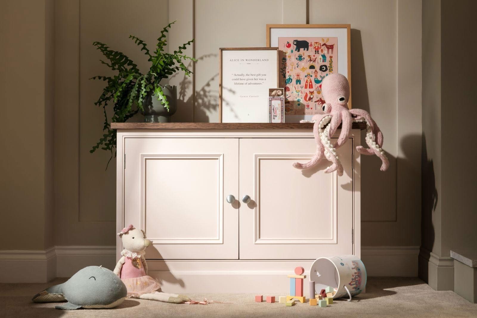 Cream freestanding nursery cabinet with panelled doors and round handles